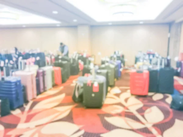 Abstract blurred luggage storage room at a luxury hotel in San Francisco, California, USA. Available for guests who want to leave bags. An unidentified employee is arranging, stack multicolor suitcase