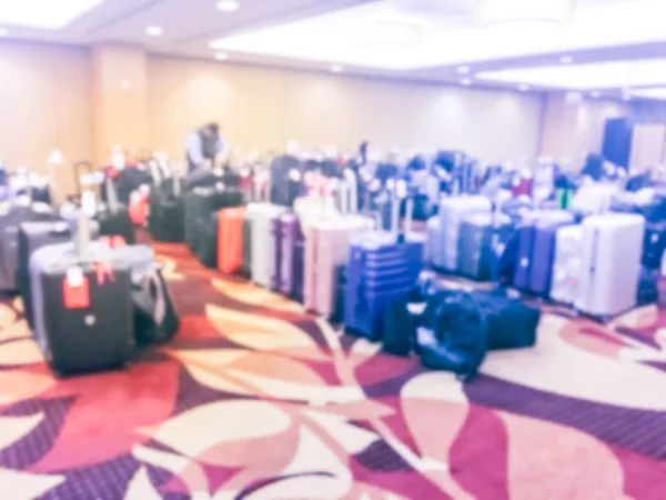 Vintage blurred luggage storage room at a luxury hotel in San Francisco, California, USA. Available for guests who want to leave bags. An unidentified employee is arranging, stack multicolor suitcase