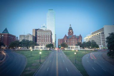 Vintage sesi güzel Dealey Plaza, Jkf suikast site Dallas gökdelenler ve hafif iz trafik görüntüleyin. Manzarası ve ulaşım cityscape mavi saatte