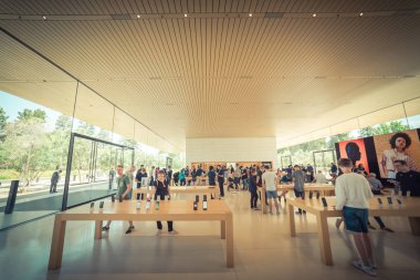 CUPERTINO, CA, US-JUL 18, 2018:Diverse group of customer experience highly curated selection of iPhone, iPad, computer product, accessories, exclusive and Apple Park branded at Apple Park retail store clipart