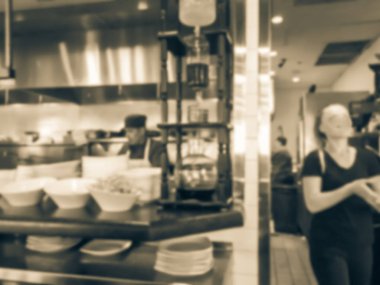 Hareket hareket Restoran Şefler Asya açık mutfakta yemek bulanık. Alma için bekleyen Garson yemekleri restoran dan emretti. Modern ve buzzy bistro iç tasarım