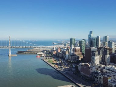 Havadan görünümü Körfez Köprüsü ve şehir San Francisco manzarası. San Francisco-Oakland Köprüsü ve finans bölgesine binalar bir parçası en iyi görünümü çift katlı süspansiyon yayılan.