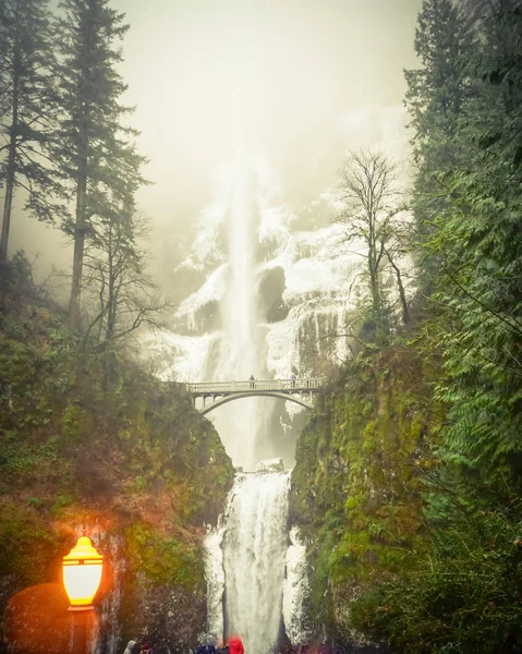 Vintage tone crowded of visitor at the main lookout of the base of Multnomah Falls in winter time. A waterfall on the Oregon side of the Columbia River Gorge, along the Historic Columbia River Highway