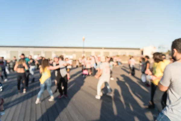 Blurred diverse group of people dancing Brazilian zouk in San Francisco at sunset. A partner dance originating from Brazil, known as zouk-lambada. Unique in both sexy full body and head movement