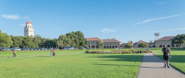 California, bize-Temmuz 18, 2018:Oval yeşil çim ve Stanford Üniversitesi Kampüsü içinde yol günbatımında. Birçok öğrenciler, ziyaretçiler ve aileler çimenli yeşil alan tadını çıkarın. Hoover kule kaldı