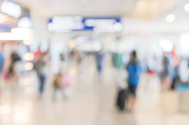 Arka plan yolcu veya Havaalanı koridor aydınlatmalı yön işareti ile yürüyen turist bulanık. Hareket bulanık insanlar Amerikan terminalde Bagaj ile git. Seyahat ve ulaşım kavramı