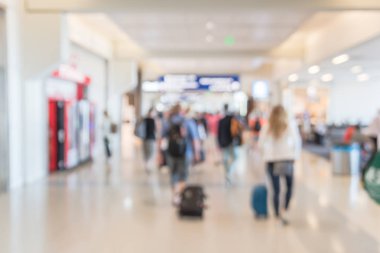 Amerikan Havaalanı'nda terminal bekleyen alanı yakınında bagajlı ufuk bulanık insanlar. Bulanık yolcu ya da turistik bir çanta soyut. Ufuk yolcusu koridor uzaklaş, arkadan görünüm