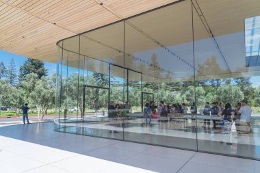 Cupertino, Ca, bize-Temmuz 18, 2018: Dış görünümü Apple Park Ziyaretçi Merkezi, Apple yeni kampüs mimari bir uzantısıdır. Zeytin ağaçları ile çevrili alan cam pencere açık ile çağdaş tasarım