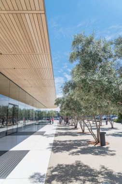 Cupertino, Ca, bize-Temmuz 18, 2018: Dış görünümü Apple Park Ziyaretçi Merkezi, Apple yeni kampüs mimari bir uzantısıdır. Zeytin ağaçları ile çevrili alan cam pencere açık ile çağdaş tasarım