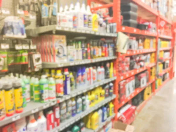 Defocused home improvement retailer store with racks of lubricant, automotive, towing, garage organization. Blurred image background of large hardware store in America