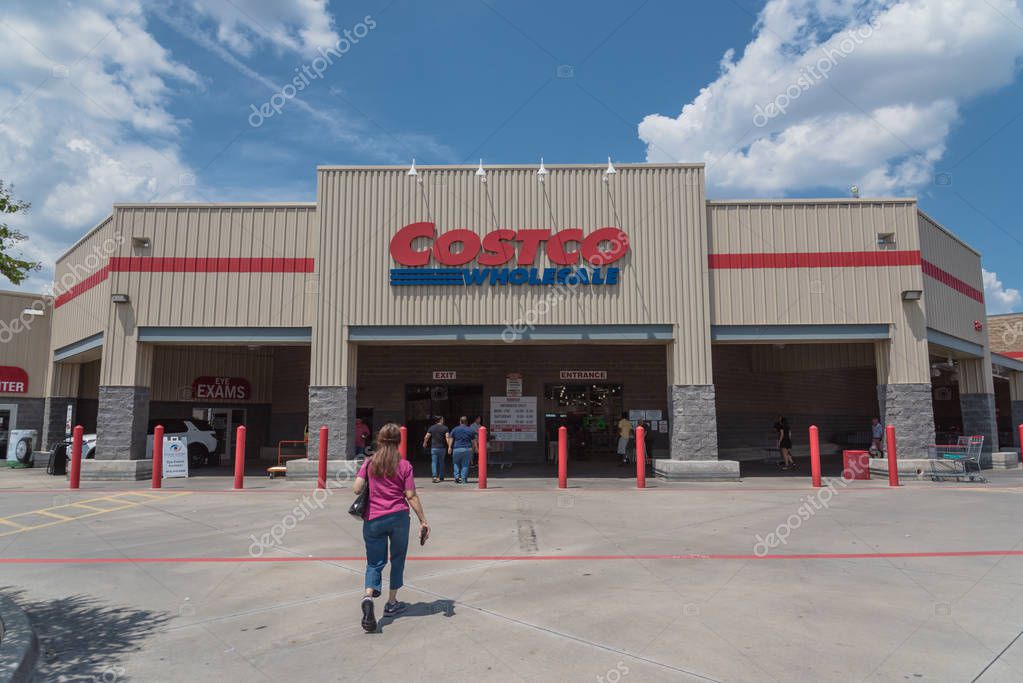 Lewisville, TX, USA-AUG 4, 2018:Customers walk in enter facade entrance Costco Wholesale storefront under cloud blue sky. It is the largest membership-only warehouse club in USA