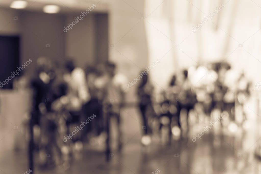 Vintage tone blur long people queuing at check-in counter lobby of museum in Fort Worth. Large group of diverse multiethnic visitors crowd family member, adult, kid, toddler waiting in separation line