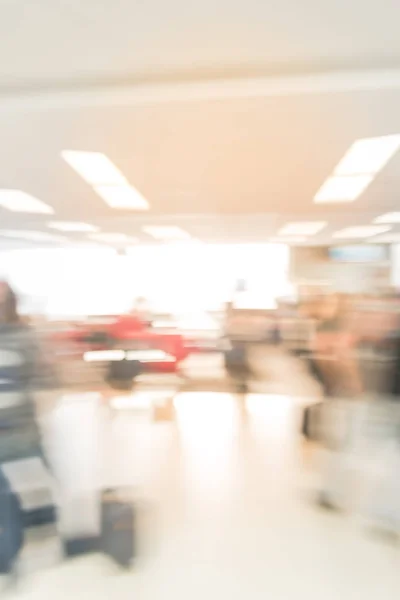 Blurred diverse group of passengers with luggage waiting in line at airport boarding gate in USA. Blurry group of travelers queuing to onboard to jet bridge airplane, final boarding gate