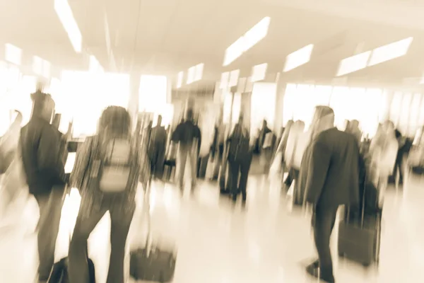 Vintage tone blurred diverse group of passengers with luggage waiting in line at airport boarding gate in USA. Blurry group of travelers queuing to onboard to jet bridge airplane, final boarding gate