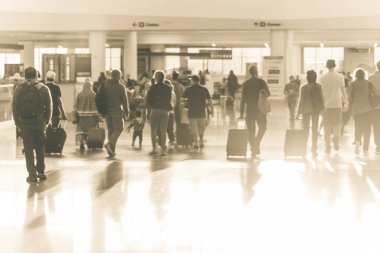 Bulanık arka plan aile üyeleri ile Bagaj Havaalanı terminal koridor boyunca yürüme. Soyut yolcu veya turistik seyahat bagaj ile bulanık. Bokeh sabah arkadan aydınlatmalı ışık