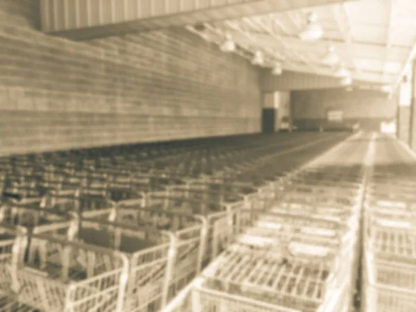 Vintage tone blurred long line of shopping carts row at entrance of retail store in America