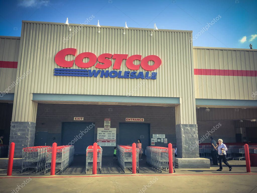 LEWISVILLE, TX, US-AUG 5, 2018:Close-up logo at facade exterior of Costco Wholesale store. Diverse group of customer waiting for opening hour in morning time, cloud blue sky