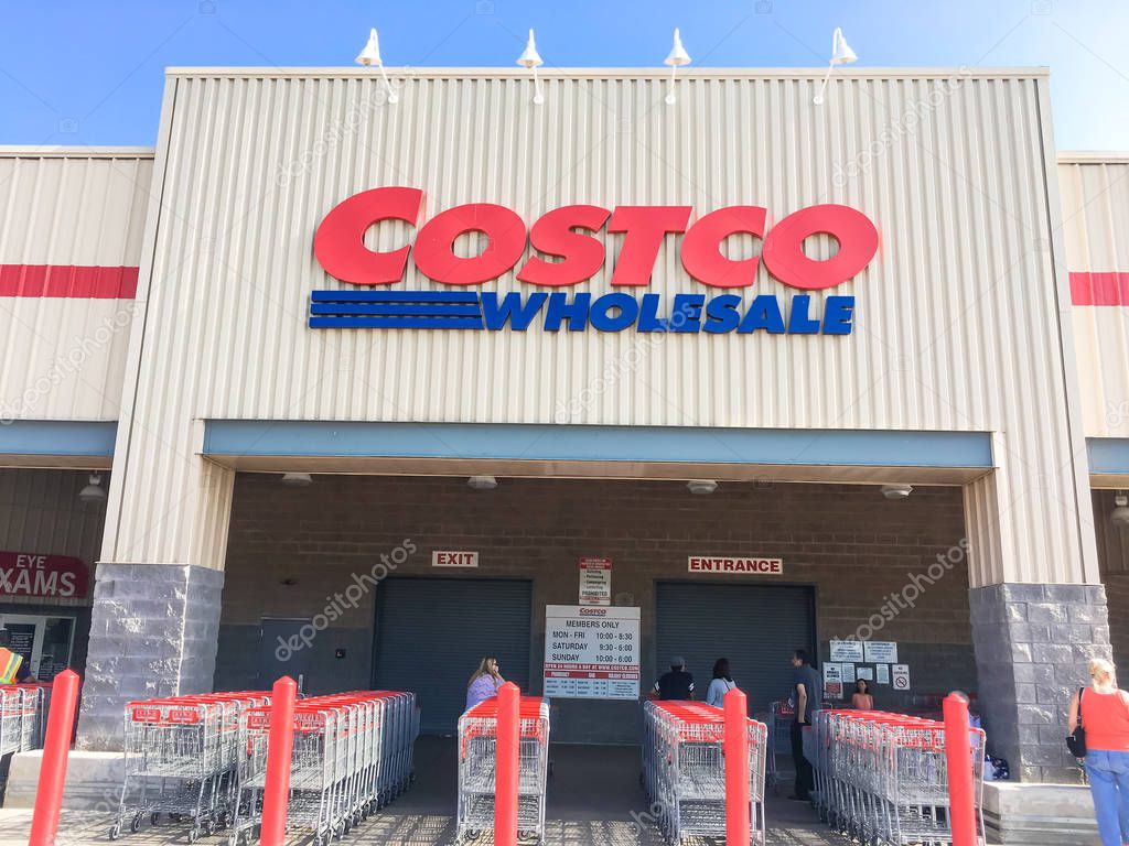 LEWISVILLE, TX, US-AUG 5, 2018:Close-up logo at facade exterior of Costco Wholesale store. Diverse group of customer waiting for opening hour in morning time, cloud blue sky
