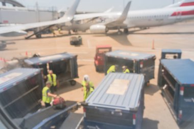 Konveyör ve Bagaj güneşli, Dallas, Texas, ABD varışta boşaltma Bagaj kamyon ile bulanık Havaalanı ekipleri.