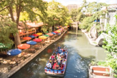 Renkli nehir yürümek şehir San Antonio, Texas, bulanıklık bize. Çok renkli şemsiye üzerinden açık kafe, Restoran. Turistler anlatı kılavuzu boyunca ünlü ve tarihi hedef ile tekne turu sürme keyfini çıkarın