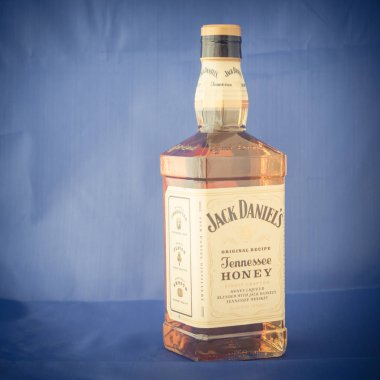Irving, Tx, bize-Ağustos 4, 2018:Side görünümü stüdyo şişe Jack Daniels Tennessee bal mavi izole vurdu. Viski ve benzersiz bal likörü, vanilya, tarçın, dengeli doğal olarak içki düzgün karışımı