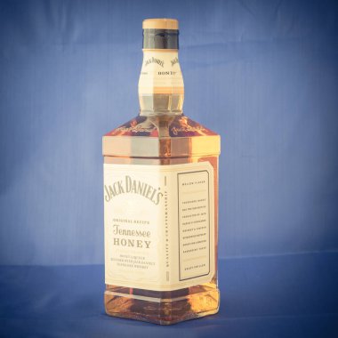Irving, Tx, bize-Ağustos 4, 2018:Side görünümü stüdyo şişe Jack Daniels Tennessee bal mavi izole vurdu. Viski ve benzersiz bal likörü, vanilya, tarçın, dengeli doğal olarak içki düzgün karışımı
