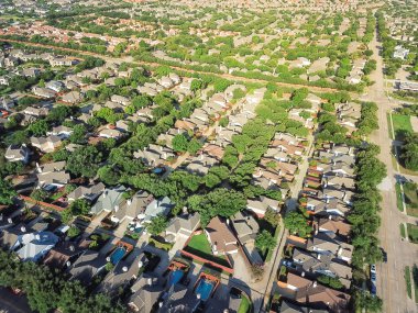 Aerial view suburb growing outside Dallas downtown in Irving, Texas, USA. Bird eye green architecture in new subdivision development of tightly packed homes with driveways, vast neighborhood suburbia clipart