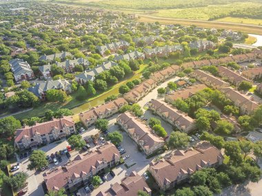 Havadan görünümü apartman kompleksi ve kanal nehir ayırıcı ile konut evleri. Irving, Texas, ABD'de büyüyen yeşil ve uyum mimari banliyösü. Büyük mahalle suburbia gün batımında