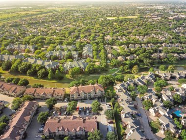 Havadan görünümü apartman kompleksi ve kanal nehir ayırıcı ile konut evleri. Irving, Texas, ABD'de büyüyen yeşil ve uyum mimari banliyösü. Büyük mahalle suburbia gün batımında