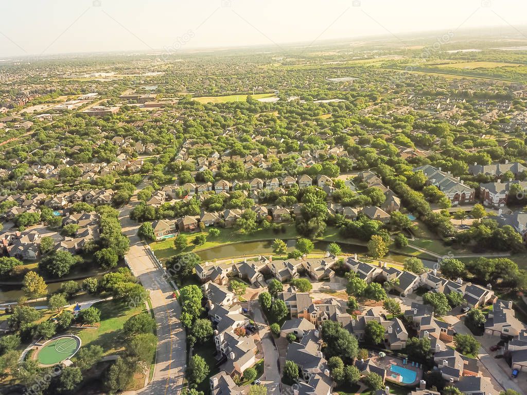 Top view urban sprawl in Dallas-Fort Worth area. Apartment building complex and suburban tightly packed homes neighborhood with driveways flyover. Vast suburbia subdivision in Irving, Texas, US