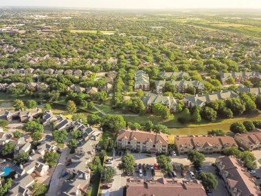 Havadan görünümü apartman kompleksi ve kanal nehir ayırıcı ile konut evleri. Irving, Texas, ABD'de büyüyen yeşil ve uyum mimari banliyösü. Büyük mahalle suburbia gün batımında