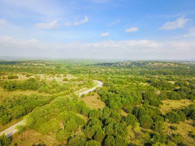 Havadan görünümü yeşil tepe peyzaj manzaralı sürücü ile haddeleme Hill Country, West Texas, ABD. Yatay kırsal ve tarım arazileri, ahır köprü, mavi gökyüzü