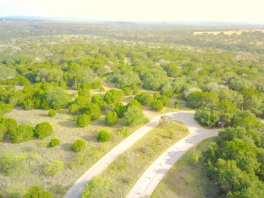 Havadan görünümü yeşil tepe peyzaj manzaralı sürücü ile haddeleme Hill Country, West Texas, ABD. Yatay kırsal ve tarım arazileri, ahır köprü, mavi gökyüzü