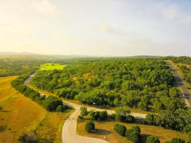 Havadan görünümü yeşil tepe peyzaj manzaralı sürücü ile haddeleme Hill Country, West Texas, ABD. Yatay kırsal ve tarım arazileri, ahır köprü, mavi gökyüzü