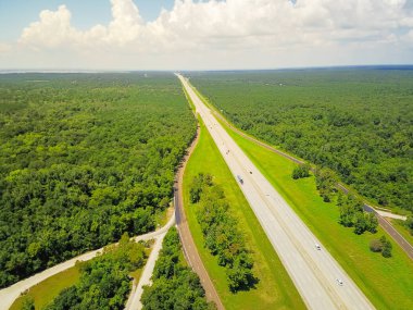 Sonsuz Interstate 10 karayolu hava Yatay Panorama Görünümü Güney Amerika Birleşik Devletleri sahne aracılığıyla çalışan. Bulut mavi gökyüzü altında yeşil meşe ağaçları ile çevrili düz yol Flyover