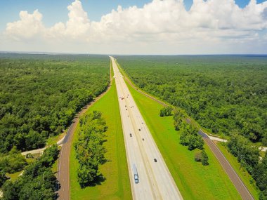 Sonsuz Interstate 10 karayolu hava Yatay Panorama Görünümü Güney Amerika Birleşik Devletleri sahne aracılığıyla çalışan. Bulut mavi gökyüzü altında yeşil meşe ağaçları ile çevrili düz yol Flyover
