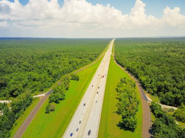 Sonsuz Interstate 10 karayolu hava Yatay Panorama Görünümü Güney Amerika Birleşik Devletleri sahne aracılığıyla çalışan. Bulut mavi gökyüzü altında yeşil meşe ağaçları ile çevrili düz yol Flyover