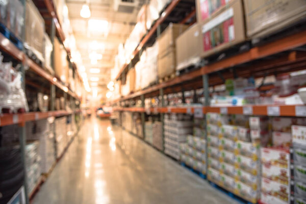 Blurred image of shelves in modern distribution warehouse or storehouse. Defocused background of industrial warehouse interior aisle. inventory, hypermarket, wholesale, logistic and export concept.