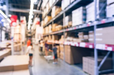 Bulanık arka plan aile üyeleri, Texas, Amerika mobilya mağazasında alışveriş meşgul. Ufuk bulanık müşteri iterek Kafesli döşeme sepeti ile araya mobilya kutusu.