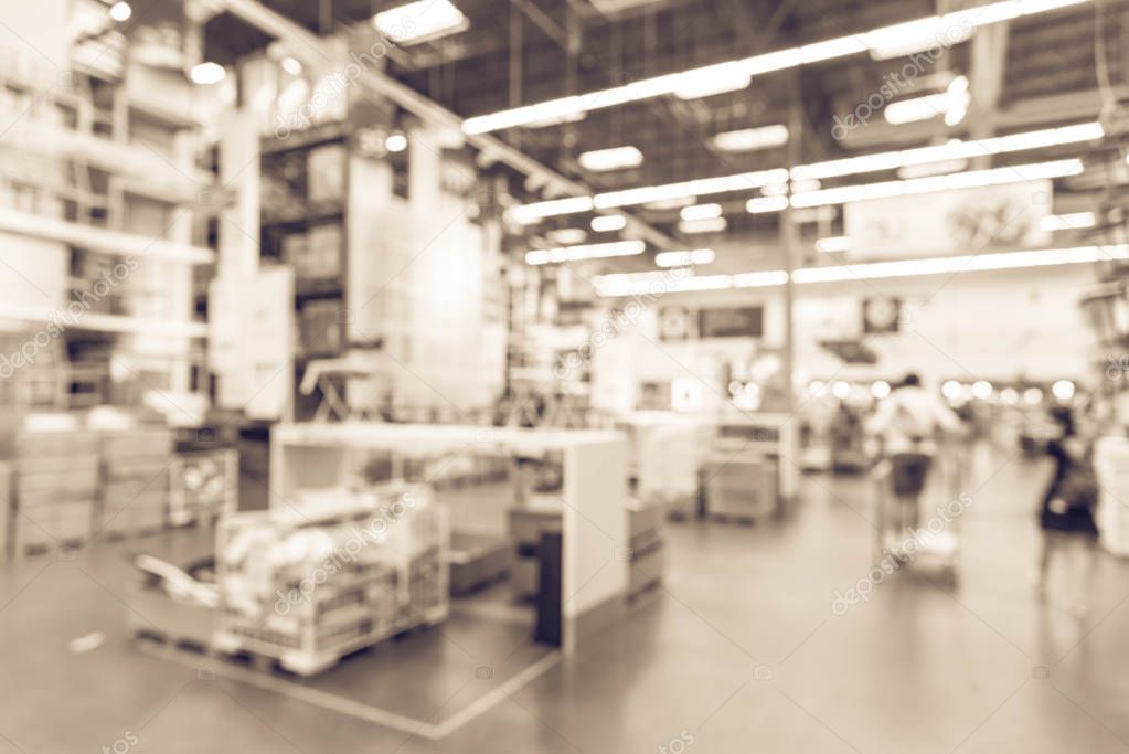 Vintage tone blurred customers shopping in large furniture warehouse with row of aisles and bins from floor to ceiling. Industrial storehouse interior. Inventory, wholesale, logistic, export