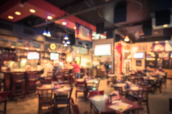 Blurred image sport and gumbo, oyster bar with TV, classic counter, tables and chairs in Houston, Texas, US. Bar Happy Hour, dine in abstract background. Night club, grill bar concept. Vintage filter.