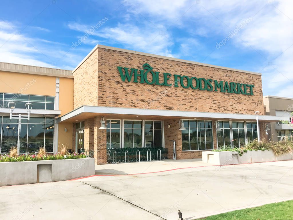 IRVING, TX, US-AUG 19, 2018:Close-up logo on exterior facade of Whole Foods Market store. An eco-minded supermarket chain featuring food without artificial preservatives, colors, flavors, sweetener