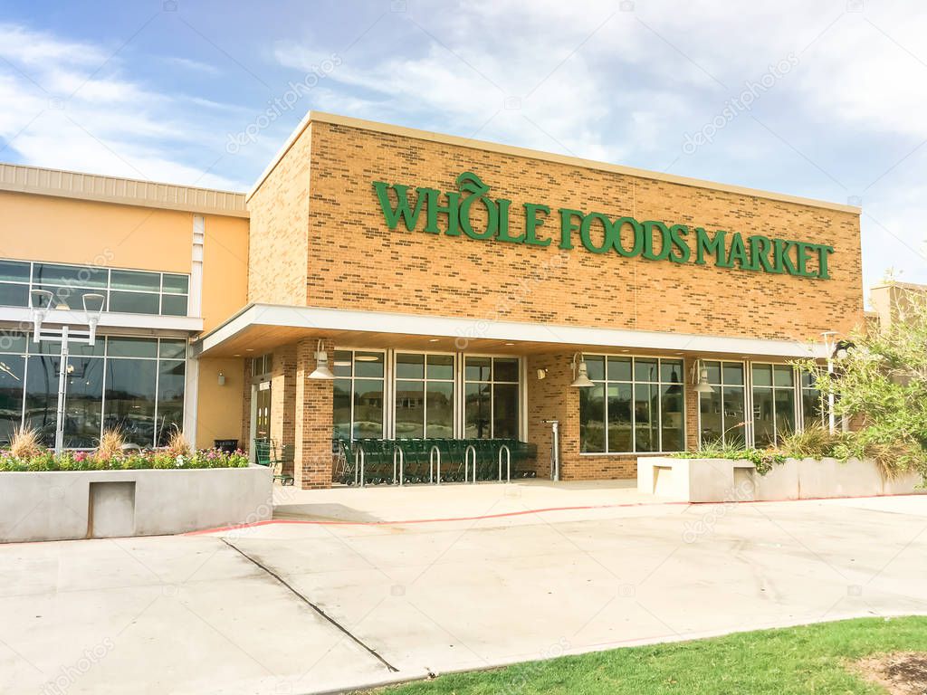 IRVING, TX, US-AUG 19, 2018:Close-up logo on exterior facade of Whole Foods Market store. An eco-minded supermarket chain featuring food without artificial preservatives, colors, flavors, sweetener