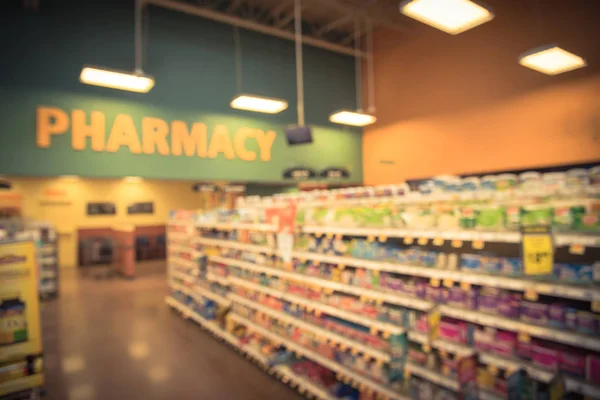 Blurred abstract background inside pharmacy store with arranged variation of pharmaceutical and medical supplies product label on shelves display. Indoor drug store with blurred medicine. Vintage look
