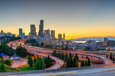 Güzel şehir Seattle gökdelenler ve turuncu gün batımında I-90 Kavşağı I-5 çevre yolu. Trafik ışığı uzun pozlama görünümünü saatinde rotaları. Jose s. ali rıza köprü görünümünden (12 Köprüsü)