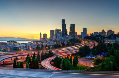 Güzel şehir Seattle gökdelenler ve turuncu gün batımında I-90 Kavşağı I-5 çevre yolu. Trafik ışığı uzun pozlama görünümünü saatinde rotaları. Jose s. ali rıza köprü görünümünden (12 Köprüsü)