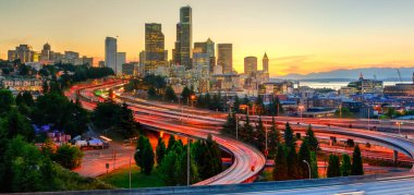 Panoramik downtown Seattle gökdelenler ve turuncu gün batımında I-90 Kavşağı I-5 çevre yolu. Uzun pozlama sırasında acele saat trafik ışığı yollarının. Jose s. ali rıza köprü görünümünden (12 Köprüsü)