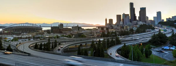 Panoramic view Seattle skylines and s-curved I-90, I-5 highway interchange traffic motion during sunset. Travel and transportation background, cityscape and high speed concept. View from Rizal Park