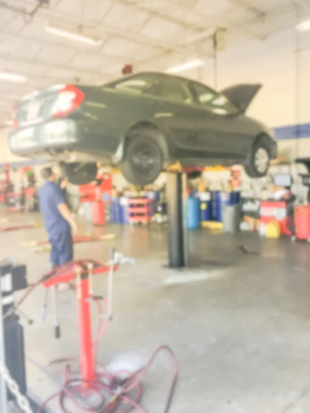 動きぼやけメカニックを調べることは テキサス州 アメリカ合衆国の自動車ショップで車を持ち上げた ガレージのコンセプトで作業技術者 — ストック写真