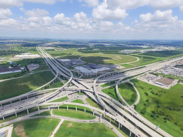 Horizontal aerial view Interstate 10 or Katy freeway massive intersection, stack interchange, elevated road junction overpass in daytime cloud blue sky. Aerial metropolitan area of Katy, Texas, USA